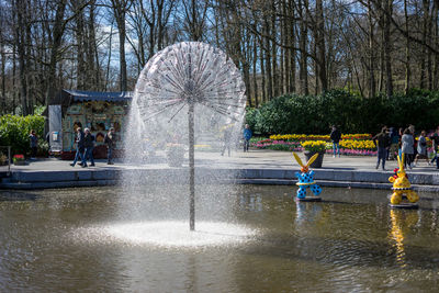 People by fountain in park