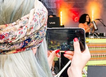 Close-up of woman photographing with mobile phone