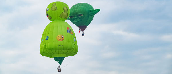 Low angle view of balloons flying against sky