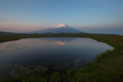 Scenic view of lake and mountains against clear sky