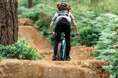 Rear view of woman walking in forest