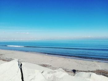 Scenic view of beach against clear blue sky