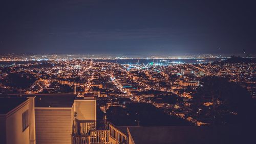 Illuminated cityscape against sky at night