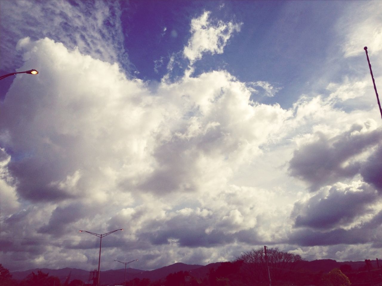 sky, low angle view, cloud - sky, fuel and power generation, electricity pylon, cloudy, electricity, power line, technology, cloud, power supply, tranquility, nature, weather, silhouette, scenics, beauty in nature, connection, tranquil scene, wind turbine