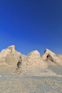 Rock formations in desert against blue sky