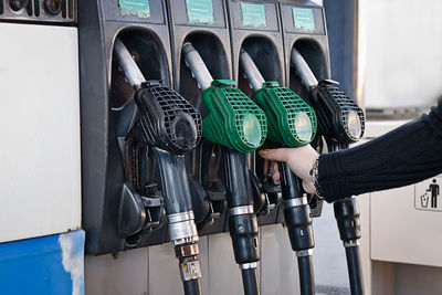 Cropped hand holding fuel pump at gas station