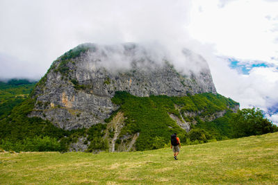 Rear view of man on mountain against sky