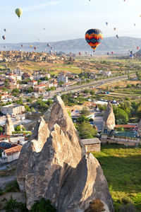 Sunny landscape of goreme city with dozens of balloons flying in the sky  in central turkey.