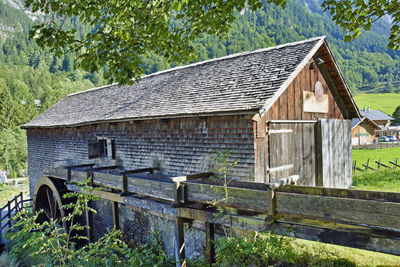 Exterior of old house on field against trees