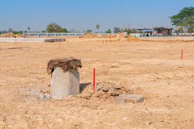 Concrete pile stake in ground after pile driver hammering in construction site.