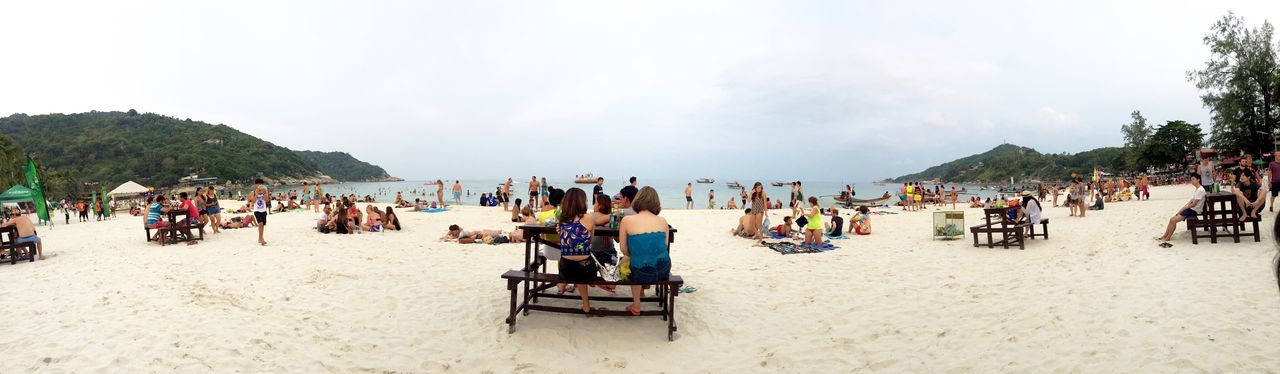 large group of people, beach, sand, vacations, person, leisure activity, relaxation, lifestyles, shore, sky, sea, mixed age range, men, water, beach umbrella, enjoyment, tourist, tourism, tree