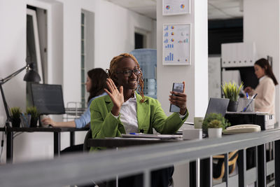 Side view of woman using digital tablet while standing in cafe