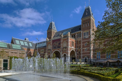 Fountain in city against sky