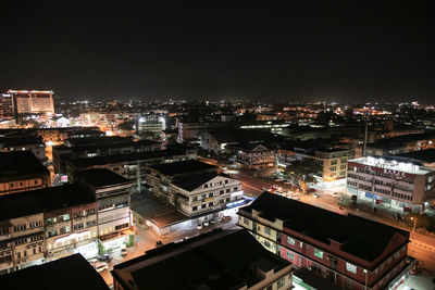 Aerial view of illuminated buildings against sky at night