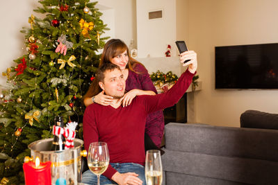 Midsection of man with woman sitting at home