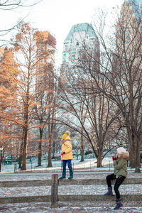 People on snow covered street in city