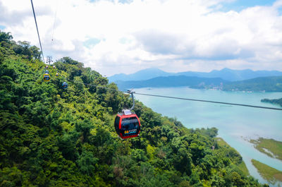 Overhead cable car over mountains against sky