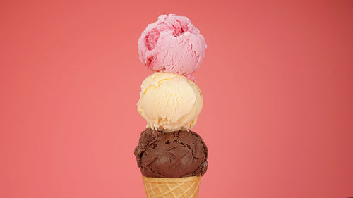 Close-up of ice cream cone against pink background