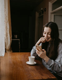 Young woman drinking coffee at home
