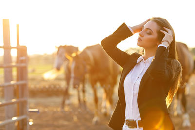 Portrait of young woman standing on field