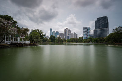 Lake by buildings against sky in city