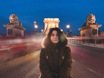 Woman standing on illuminated city at night