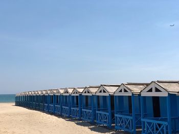 Beach huts against clear blue sky