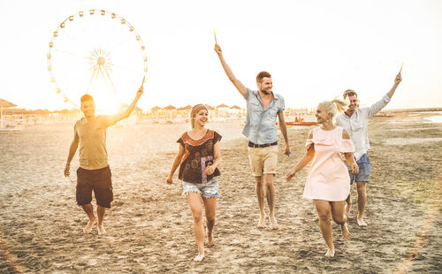 Full length of happy friends walking at beach