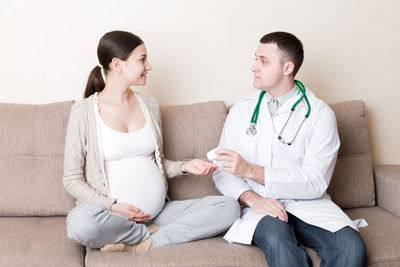 Doctor is giving pills to a pregnant woman and explaining how to use them. treatment 