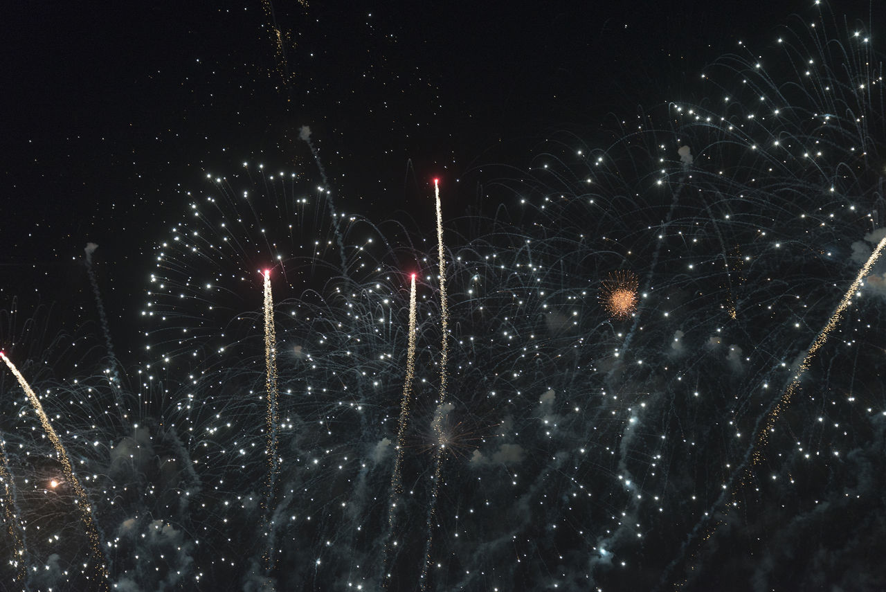 LOW ANGLE VIEW OF FIREWORKS AT NIGHT