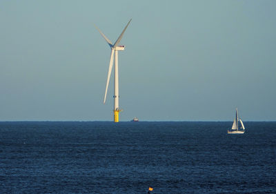 Sailboat in sea against clear sky