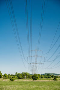 Electricity pylon on field against sky