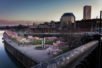 View of illuminated cityscape against sky during sunset