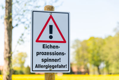 Close-up of road sign against trees