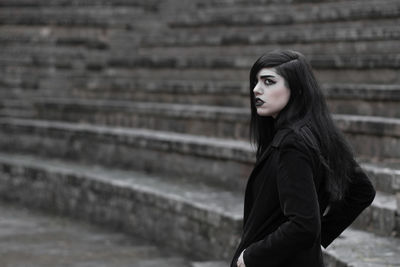 Portrait of beautiful woman standing on staircase