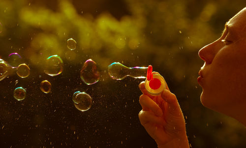 Cropped image of woman blowing bobbles