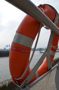 Close-up of boat moored at harbor against sky