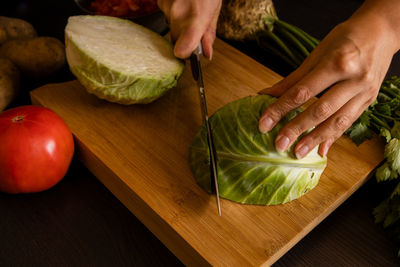 Cropped image of man holding fruit on cutting board