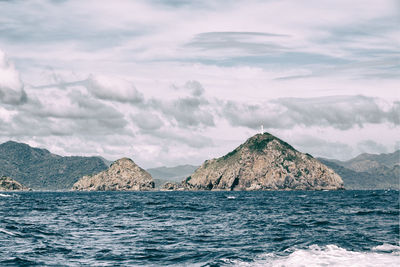 Scenic view of sea and mountains against sky