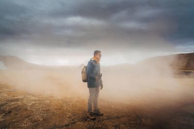 Full length of man standing on landscape against sky