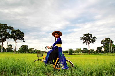 Vietnamese woman with bicycle in farm