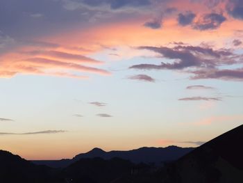 Low angle view of silhouette mountains against romantic sky