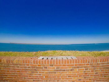 Scenic view of beach against clear blue sky