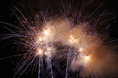 Low angle view of firework display at night