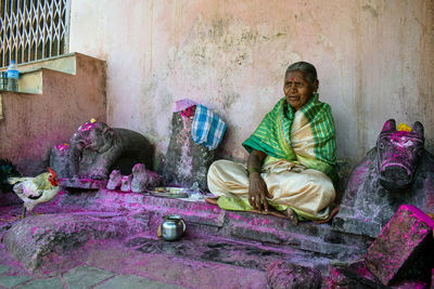 Full length of a man sitting against wall