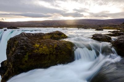 Scenic view of waterfall against sky