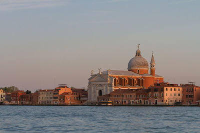 Canal amidst buildings against sky