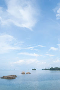 Islands in sea against cloudy sky