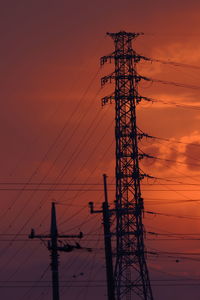 Low angle view of silhouette electricity pylon against sky during sunset