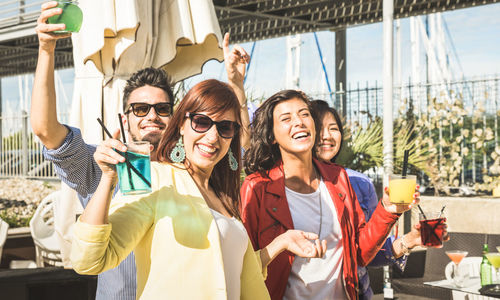 Portrait of cheerful friends enjoying party at beach